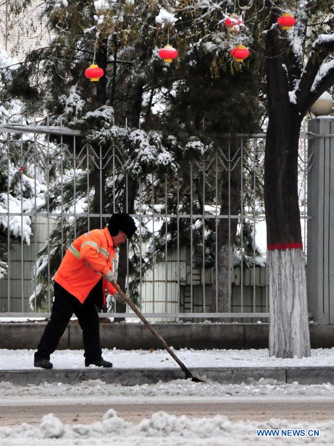 A sanitation worker clears snow in Hohhot, capital of north China's Inner Mongolia Autonomous Region, Nov. 10, 2012. A heavy snowfall hit Hohhot on Nov. 9. (Xinhua/Deng Hua) 