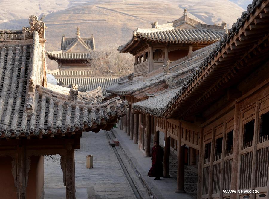 Lama Cering Duanzhi stands at a corridor at the Qutan Temple in Ledu County, northwest China's Qinghai Province, Nov. 10, 2012. The Qutan Temple of the Tibetan Buddhism started to be built in 1393 during ancient China's Ming Dynasty (1368-1644). (Xinhua/Wang Bo)