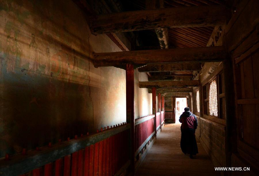Lama Cering Duanzhi walks in a corridor at the Qutan Temple in Ledu County, northwest China's Qinghai Province, Nov. 10, 2012. The Qutan Temple of the Tibetan Buddhism started to be built in 1393 during ancient China's Ming Dynasty (1368-1644). (Xinhua/Wang Bo)