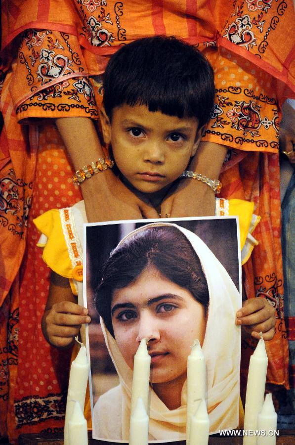A Pakistani boy holds a photo of Pakistan's child activist Malala Yousafzai to mark the "Malala Day" in Karachi, Pakistan, Nov. 10, 2012. (Xinhua/Masroor)
