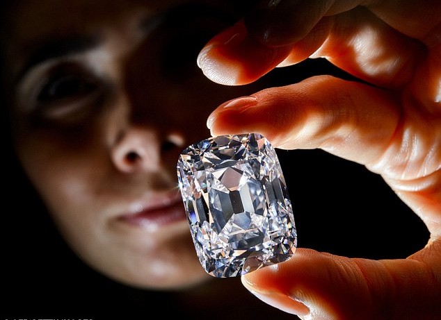 An employee poses with the Archduke Joseph Diamond during an auction preview at Christie's in Geneva, Switzerland, on Nov. 8, 2012. The 76.02 carat diamond is expected to be sold for over 15 million U.S. dollars when it is auctioned on Nov. 13. (Photo/Chinadaily.com.cn)