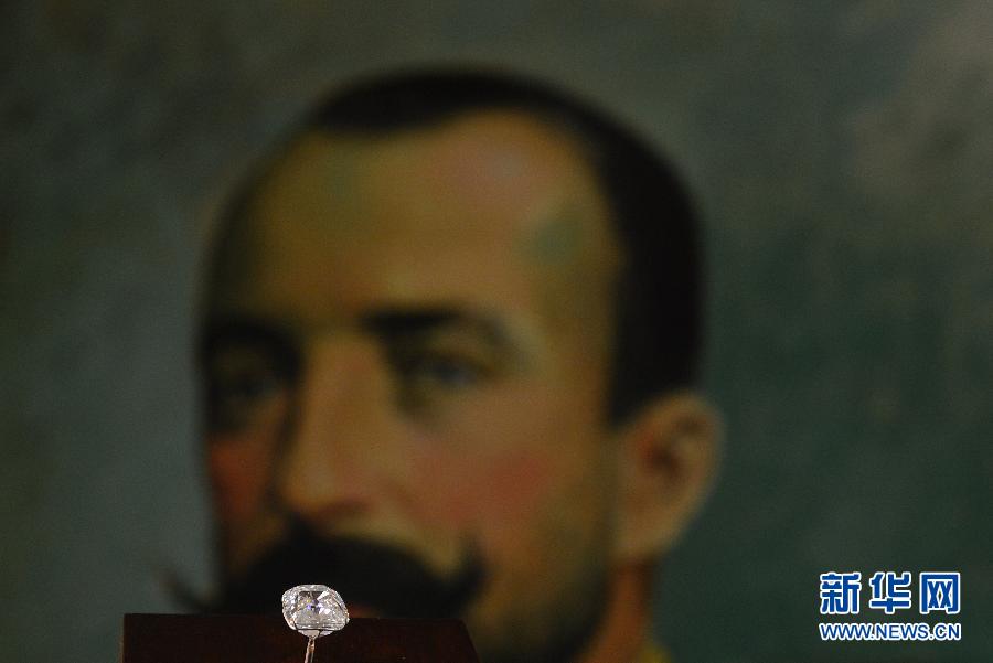 An employee poses with the Archduke Joseph Diamond during an auction preview at Christie's in Geneva, Switzerland, on Nov. 8, 2012. The 76.02 carat diamond is expected to be sold for over 15 million U.S. dollars when it is auctioned on Nov. 13. (Xinhua/Wang Siwei)