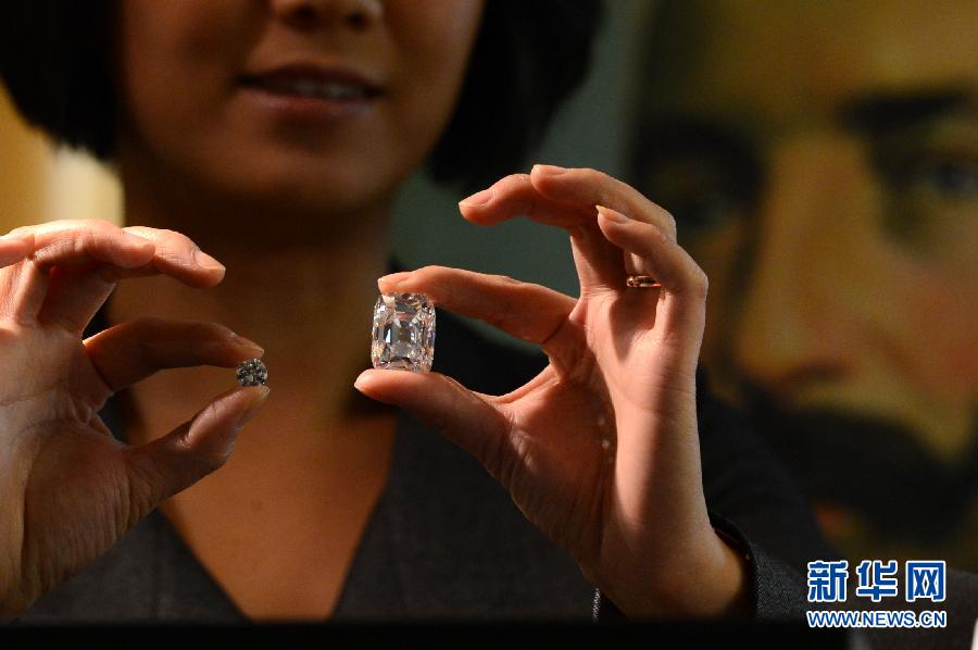 An employee poses with the Archduke Joseph Diamond during an auction preview at Christie's in Geneva, Switzerland, on Nov. 8, 2012. The 76.02 carat diamond is expected to be sold for over 15 million U.S. dollars when it is auctioned on Nov. 13. (Xinhua/Wang Siwei)