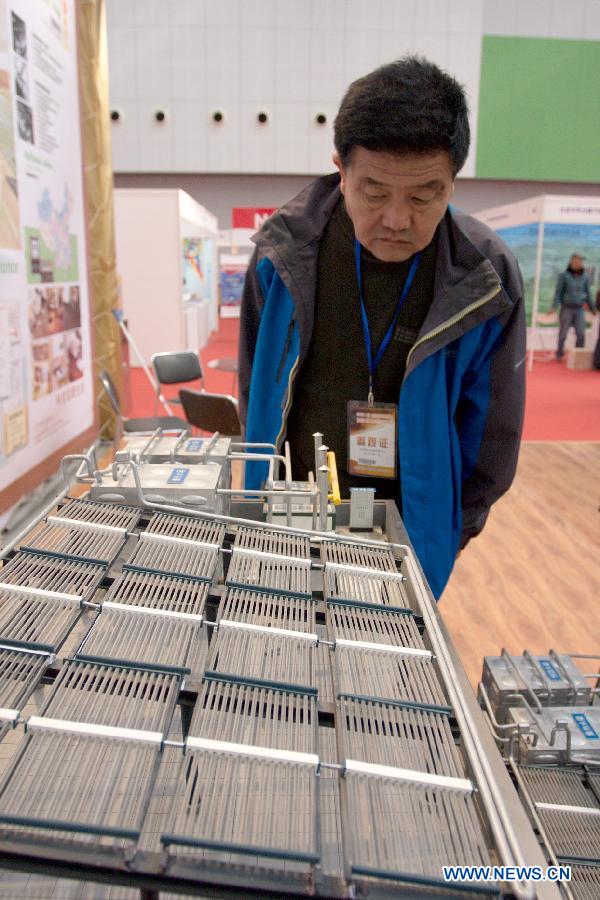Visitors listen to the introduction of a latest solar heating system at the "2012 International Building Materials and Decoration Fair" in north China's Tianjin Municipality, Nov. 9, 2012. The fair, with the participation of more than 800 enterprises, opened here on Friday. (Xinhua/Wang Qingyan)
