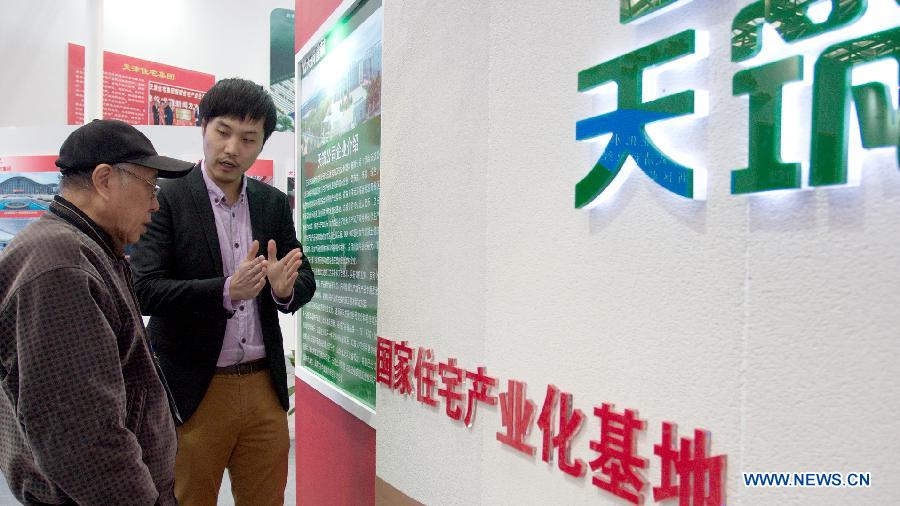 A visitor listens to the introduction of a latest energy-saving wall at the "2012 International Building Materials and Decoration Fair" in north China's Tianjin Municipality, Nov. 9, 2012. The fair, with the participation of more than 800 enterprises, opened here on Friday. (Xinhua/Wang Qingyan)
