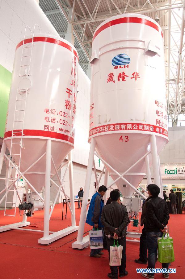 Visitors listen to the introduction of an intelligent storage tank at the "2012 International Building Materials and Decoration Fair" in north China's Tianjin Municipality, Nov. 9, 2012. The fair, with the participation of more than 800 enterprises, opened here on Friday. (Xinhua/Wang Qingyan)