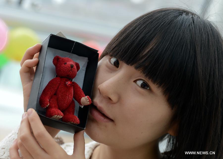 A girl poses for pictures with a Teddy Bear she bought at a Teddy Bear Museum in Chengdu, capital of southwest China's Sichuan Province, Nov. 11, 2012. (Xinhua/Jiang Hongjing) 