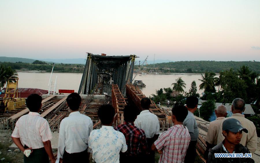 People look at the earthquake-striken Ayeyawaddy-river-crossing bridge,under construction, in Kyaukmyaung town of Sagaing Region in Myanmar, on Nov.11, 2012. A strong earthquake measuring 6.8 on the Richter scale struck Myanmar's northern Mandalay region Sunday morning, according to Nay Pyi Taw Hydrology and Meteorology Department. At least 6 people dead and 64 people injured in the earthquake. (Xinhua/U Aung)