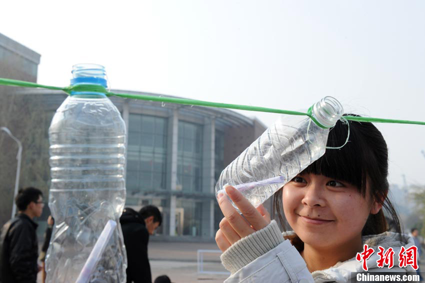 A student takes out notes from a bottle on campus of Jilin University of Finance and Economics on Nov.10, 2012. Recently, plastic bottles contained personal information and wishes notes were hanged out on the campus. Most of the notes came from some other universities. The activity named “College green drift bottles on Single's Day” attracted more than 60,000 students from 200 universities to participate in since the beginning of November. The students wanted to express their support for environmental protection, at the same time hoped to have a beautiful encounter with love on this special day. (Chinanews.com/Zhang Yao)