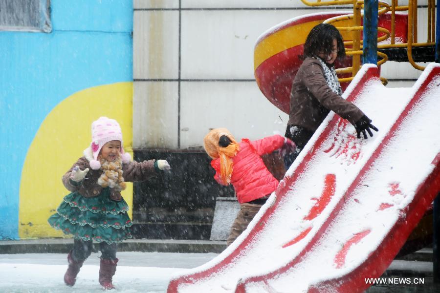 Kids play in the snow with a parent in a kindergarten in Harbin, capital of northeast China's Heilongjiang Province, Nov. 12, 2012. Many parts of China's northeast region witnessed an extensive snowfall on Sunday and Monday. (Xinhua/Wang Kai) 