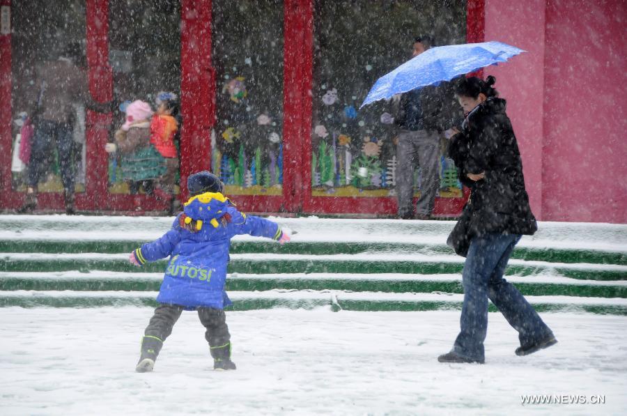A boy plays snowball with his parent in a kindergarten in Harbin, capital of northeast China's Heilongjiang Province, Nov. 12, 2012. Many parts of China's northeast region witnessed an extensive snowfall on Sunday and Monday. (Xinhua/Wang Kai)  