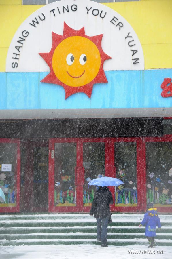 A parent takes his son to kindergarten in the snow in Harbin, capital of northeast China's Heilongjiang Province, Nov. 12, 2012. Many parts of China's northeast region witnessed an extensive snowfall on Sunday and Monday. (Xinhua/Wang Kai)  