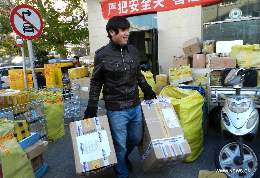 A working staff from an express company loads packs in Xicheng District of Beijing, capital of China, Nov. 12, 2012. The annual Single's Day which falls on Nov. 11 has become a shopping festival under a continuous sales promotion of e-business groups. Great discounts resulted in a sharp increase of online trades which cause enormous pressure on express service. (Xinhua/Wang Zhen)  