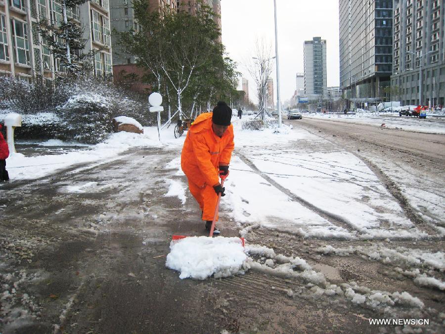 A sanitation worker cleans snow on a road in Shenyang, capital of northeast China's Liaoning Province, Nov. 12, 2012. A cold front is sweeping across the country's northern areas, bringing heavy snow and blizzards. (Xinhua/Cao Yang)  
