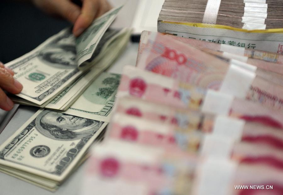 A worker counts the U.S. dollars at a bank in Qionghai City, south China's Hainan Province, Nov. 12, 2012. The Chinese currency Renminbi, or the yuan, strengthened 92 basis points to 6.2920 against the U.S. dollar on Monday, according to the China Foreign Exchange Trading System. (Xinhua/Meng Zhongde) 