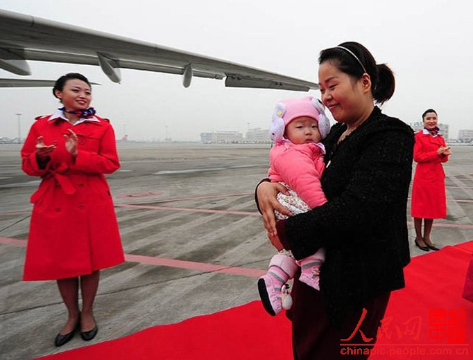 Luo Wei, a deputy to the 18th National Congress of the Communist Party of China from Sichuan, is going to board the plane to Beijing to attend the Congress with her five-month-old daughter. (Photo/ People’s Daily Online) 
