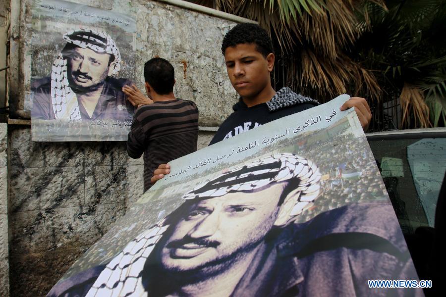 A Palestinian young man holds a poster showing late Palestinian leader Yasser Arafat in West Bank city of Nablus, on Nov. 11, 2012, marking the eighth anniversary of Arafat's death. (Xinhua/Nidal Eshtayeh)