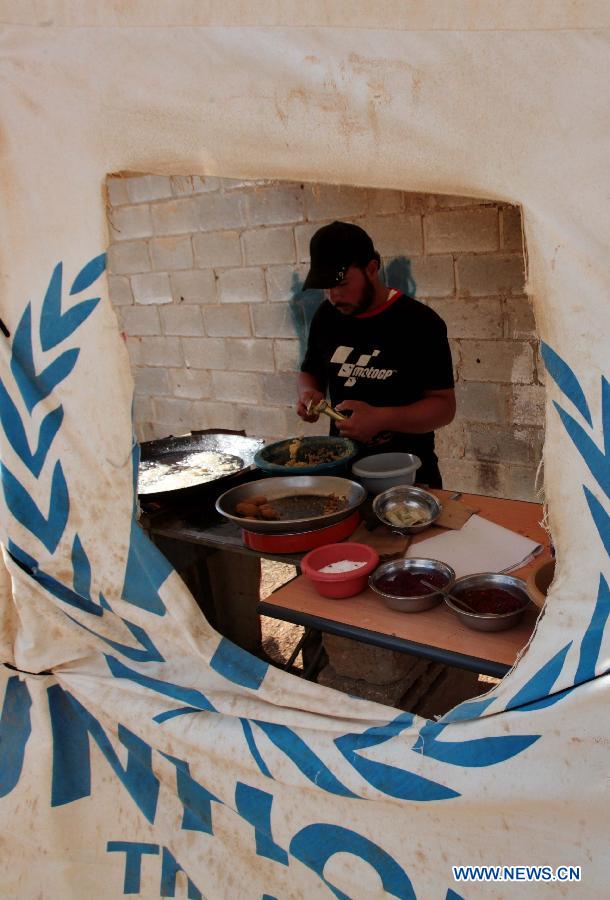 A man makes Syrian traditional food Flafel for sale at Al Zaatri Syrian refugee camp in the Jordanian city of Mafraq, near the border with Syria, on Nov. 12, 2012. (Xinhua/Mohammad Abu Ghosh)