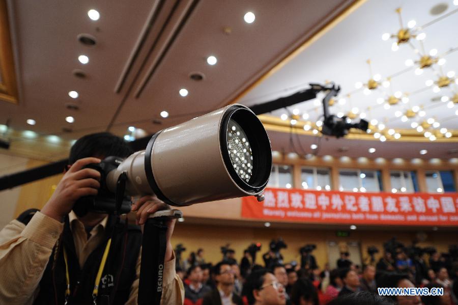 A photographer takes photos at a press conference held by the press center of the 18th National Congress of the Communist Party of China (CPC) in Beijing, capital of China, Nov. 12, 2012.(Xinhua/Li Xin)