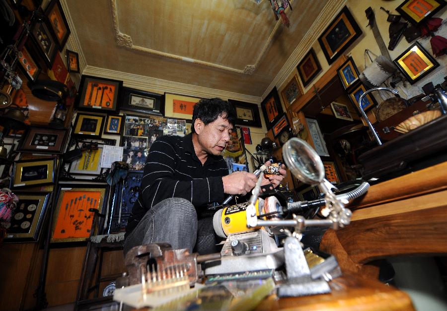 Tong Fucun polishes a piece of his collection in Taiyuan, capital of north China's Shanxi Province, Nov.11, 2012. (Xinhua/Yan Yan) 