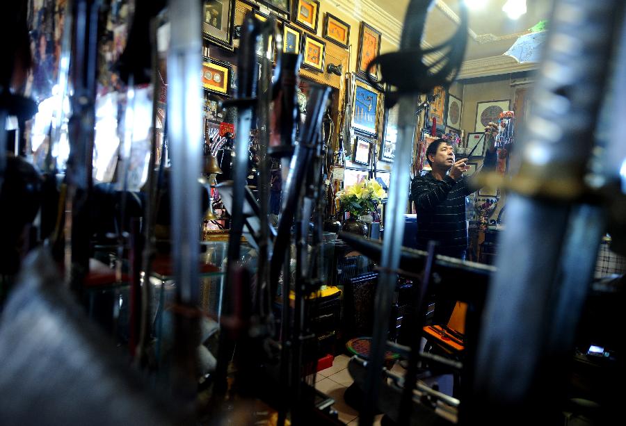 Tong Fucun categorizes his collection in Taiyuan, capital of north China's Shanxi Province, Nov.11, 2012. (Xinhua/Yan Yan) 