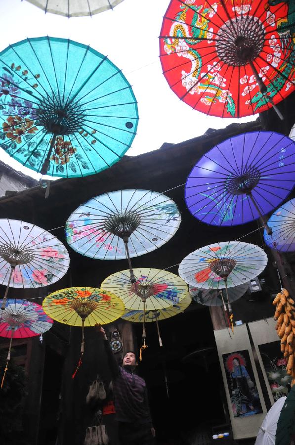 A craftsman checks oil-paper umbrellas at a workshop in Xixiu District of Anshun City, southwest China's Guizhou Province, Nov. 12, 2012. Made of oiled paper and bamboo frame, oil-paper umbrella is a traditional Chinese handicraft. The skills of making oil-paper umbrellas were introduced to Guizhou in early Ming Dynasty (1368-1644). (Xinhua/Huang Yong) 