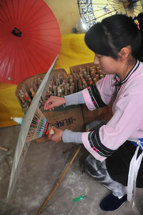 A worker processes an oil-paper umbrella at a workshop in Xixiu District of Anshun City, southwest China's Guizhou Province, Nov. 12, 2012. Made of oiled paper and bamboo frame, oil-paper umbrella is a traditional Chinese handicraft. The skills of making oil-paper umbrellas were introduced to Guizhou in early Ming Dynasty (1368-1644). (Xinhua/Huang Yong) 