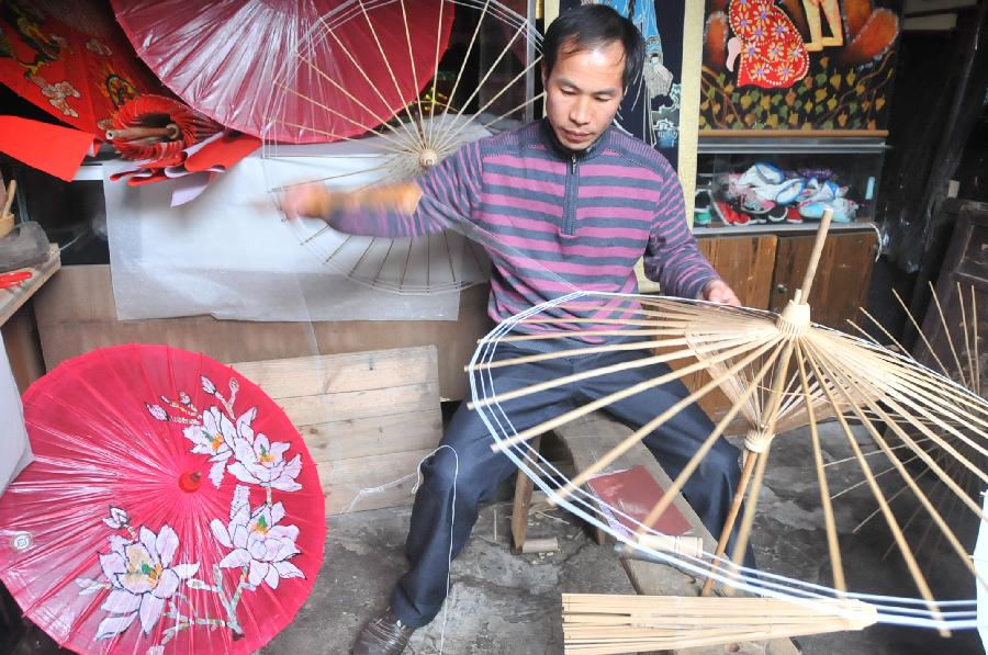 A craftsman makes oil-paper umbrellas at a workshop in Xixiu District of Anshun City, southwest China's Guizhou Province, Nov. 12, 2012. Made of oiled paper and bamboo frame, oil-paper umbrella is a traditional Chinese handicraft. The skills of making oil-paper umbrellas were introduced to Guizhou in early Ming Dynasty (1368-1644). (Xinhua/Huang Yong) 