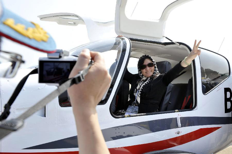 A visitor pose for photo during the opening ceremony of the 9th China International Aviation and Aerospace Exhibition in Zhuhai, south China's Guangdong Province, Nov. 13, 2012. About 650 exhibitors in the aviation and aerospace field took part in the six-day event. (Xinhua/Liang Xu) 