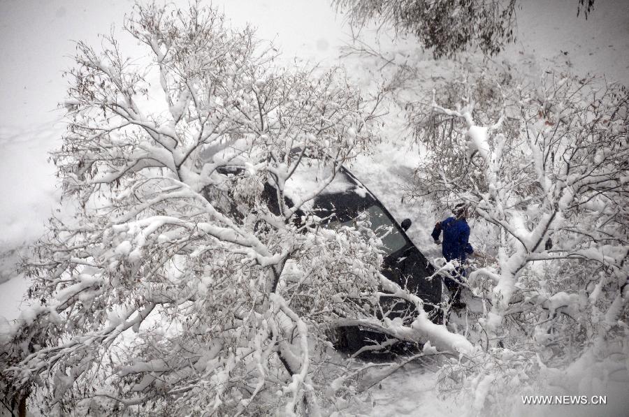 A citizen cleans a snow-covered road in Hegang, northeast China's Heilongjiang Province, Nov. 13, 2012. The city witnessed an intense snowfall since Nov. 11. (Xinhua/Wang Kai) 