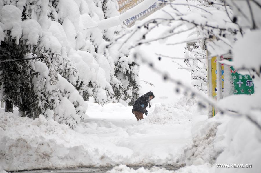 A citizen cleans a snow-covered road in Hegang, northeast China's Heilongjiang Province, Nov. 13, 2012. The city witnessed an intense snowfall since Nov. 11. (Xinhua/Wang Kai)  