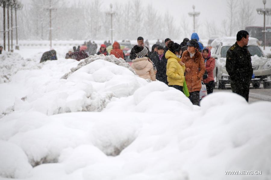 Citizens wait for buses on a snow-covered road in Hegang, northeast China's Heilongjiang Province, Nov. 13, 2012. The city witnessed an intense snowfall since Nov. 11. (Xinhua/Wang Kai) 