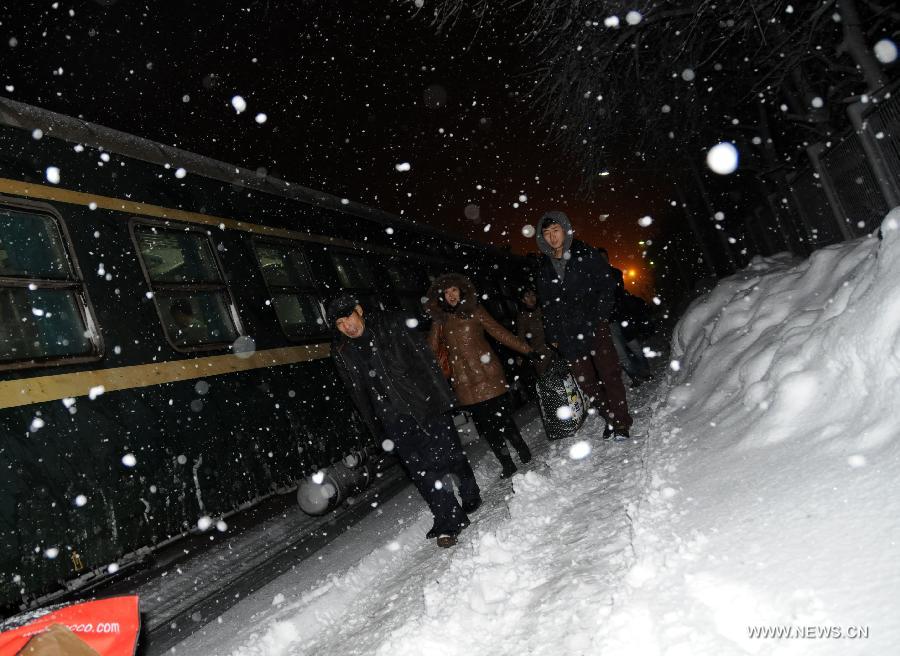 Passengers walk against the snow in Hegang Railway Station in Hegang, northeast China's Heilongjiang Province, Nov. 13, 2012. The city witnessed an intense snowfall since Nov. 11. (Xinhua/Wang Kai) 