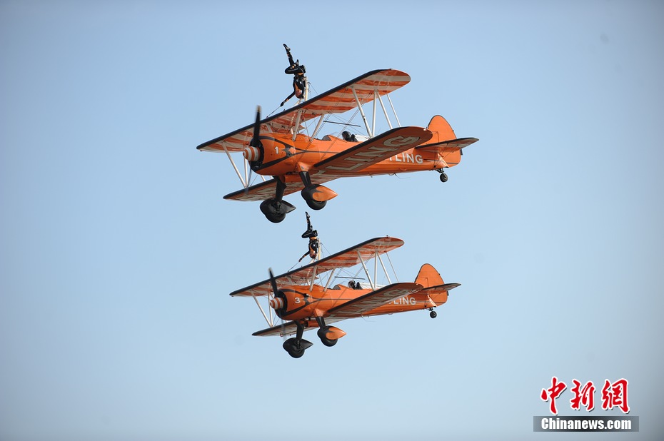Photo taken on Nov. 11, 2012 shows the wingwalkers of Beritling Jet Tem, a famous European aerobatic team, putting on wonderful performance on the wings of biplaines during a test flight for the Airshow China 2012. The airshow kicked off on Tuesday morning in south China’s Zhuhai. (Photo/Chinanews.com)