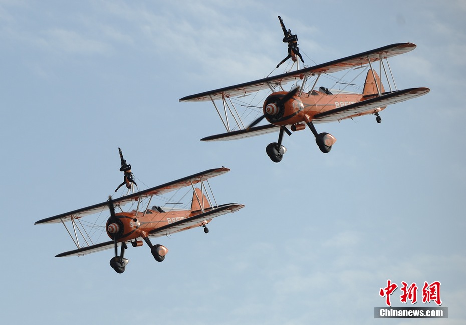 Photo taken on Nov. 11, 2012 shows the wingwalkers of Beritling Jet Tem, a famous European aerobatic team, putting on wonderful performance on the wings of biplaines during a test flight for the Airshow China 2012. The airshow kicked off on Tuesday morning in south China’s Zhuhai. (Photo/Chinanews.com)