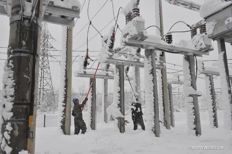 Electricians clear snow from power facilities in snow in Hegang, northeast China's Heilongjiang Province, Nov. 13, 2012. Snowstorms in recent days have affected road traffic and caused difficulties to local people in northeast China. (Xinhua) 