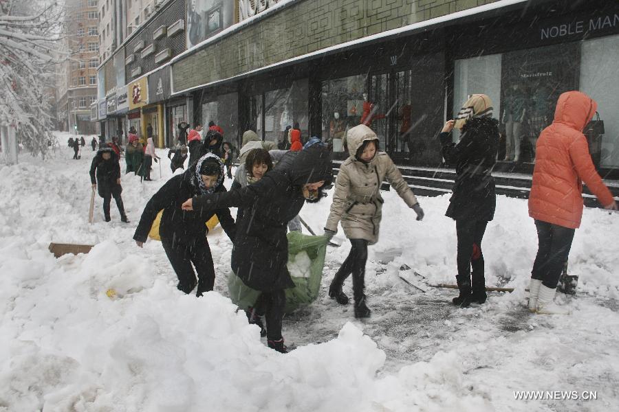 Residents clean snow on a raod in Hegang, northeast China's Heilongjiang Province, Nov. 12, 2012. Snowstorms in recent days have affected road traffic and caused difficulties to local people in northeast China. (Xinhua/Bai Changhai) 
