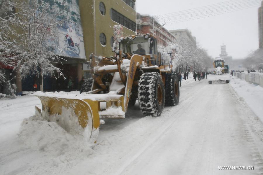 A bulldozer cleans snow on a raod in Hegang, northeast China's Heilongjiang Province, Nov. 12, 2012. Snowstorms in recent days have affected road traffic and caused difficulties to local people in northeast China. (Xinhua/Bai Changhai)