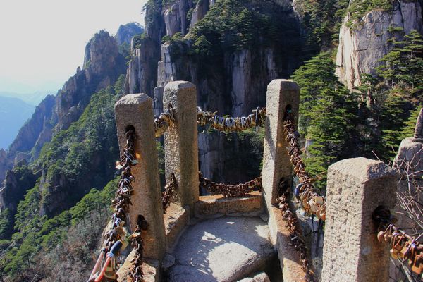 Lovers symbolically lock themselves together via a lock on the heights of Mount Huangshan. [Photo: CRIENGLISH.com/William Wang]