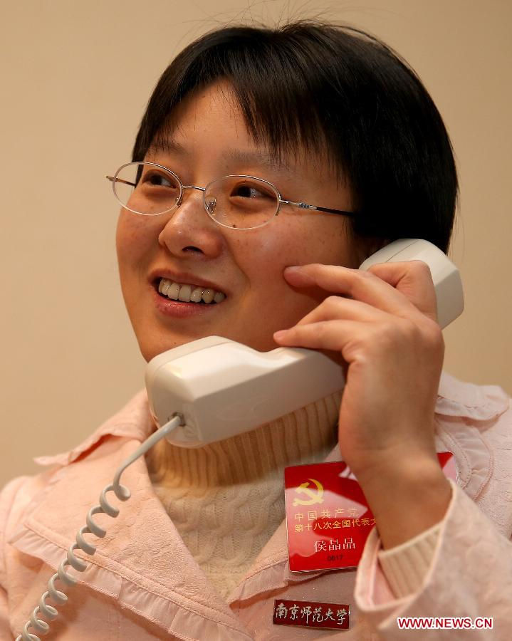 Hou Jingjing (L), a delegate to the 18th National Congress of the Communist Party of China (CPC), receives a telephone interview at a hotel room in Beijing, capital of China, Nov. 11, 2012. (Xinhua/Chen Jianli)