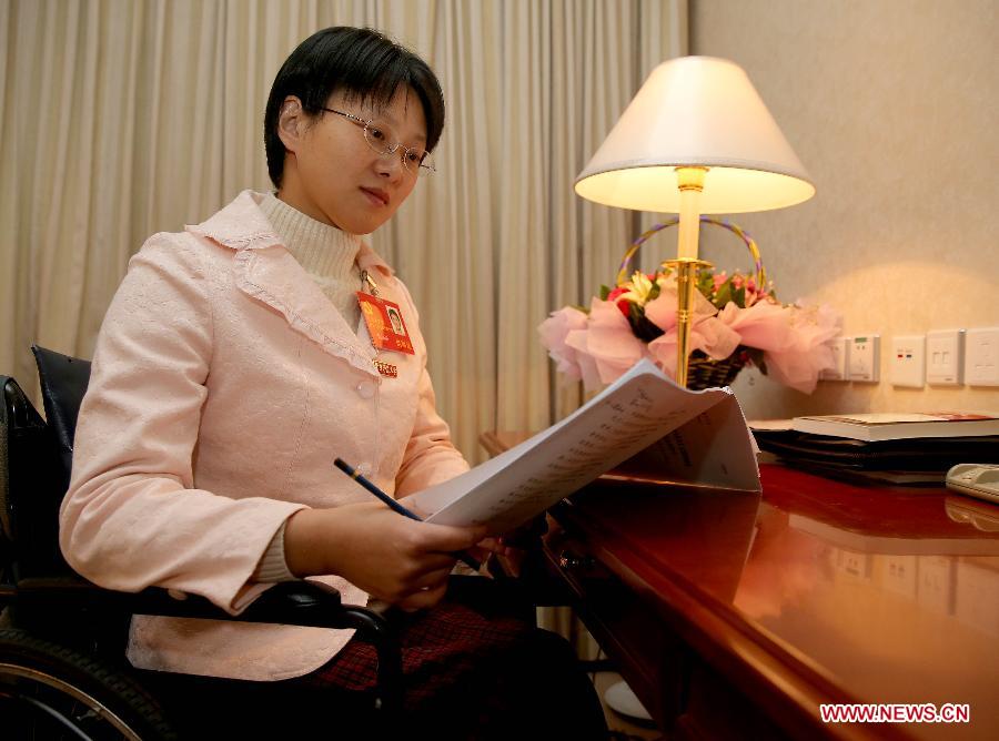 Hou Jingjing, a delegate to the 18th National Congress of the Communist Party of China (CPC), reads report at a hotel room in Beijing, capital of China, Nov. 11, 2012. (Xinhua/Chen Jianli)