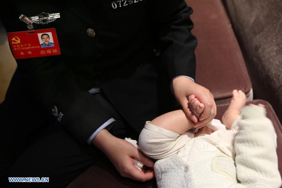 Jiang Min, a delegate to the 18th National Congress of the Communist Party of China (CPC), takes care of her son in Beijing, capital of China, Nov. 13, 2012.(Xinhua/Jin Liwang)