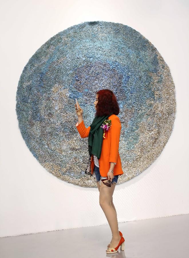 A visitor views artworks at the 7th International Fiber Art Biennale and Symposium in Nantong, east China's Jiangsu Province, Nov. 12, 2012. More than 300 artworks from 37 countries and regions were displayed during the exhibition, which was slated from Nov. 8 to Dec. 5. (Xinhua/Huang Zhe) 