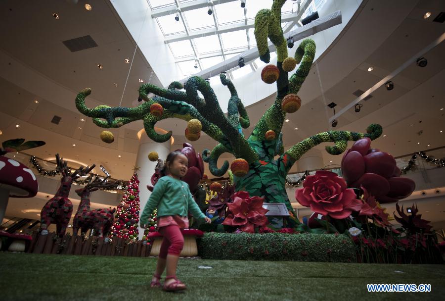 A girl walks past a large hand-crocheted Christmas tree in a shopping mall in south China's Hong Kong, Nov. 13, 2012. (Xinhua/Lui Siu Wai) 