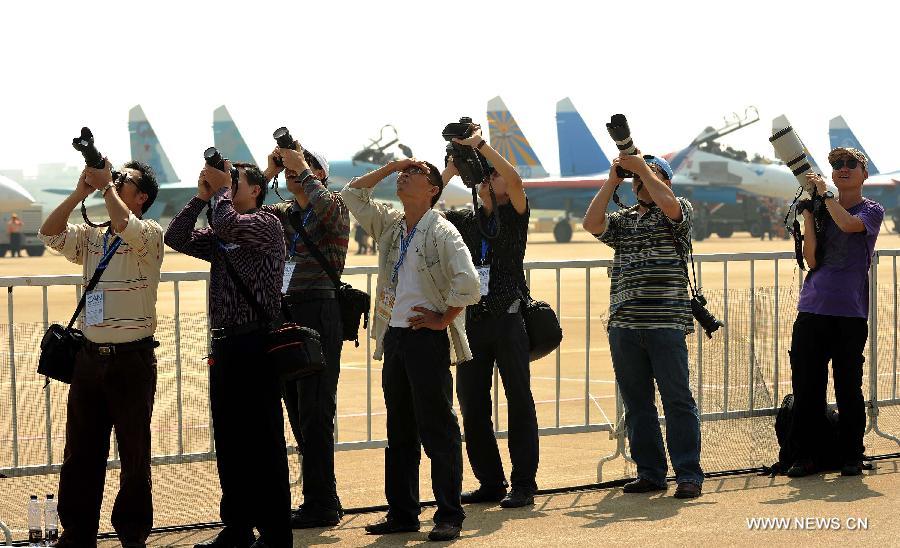 Photographers shoot aerobatic performance during the 9th China International Aviation and Aerospace Exhibition in Zhuhai, south China's Guangdong Province, Nov. 13, 2012. (Xinhua/Liu Dawei) 