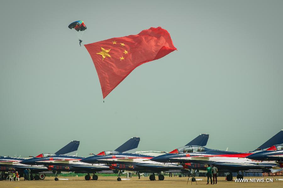 A member of the Bayi Parachute Team of the People's Liberation Army (PLA) Air Force parachutes with a huge Chinese national flag during the 9th China International Aviation and Aerospace Exhibition in Zhuhai, south China's Guangdong Province, Nov. 13, 2012. (Xinhua/Liu Dawei) 