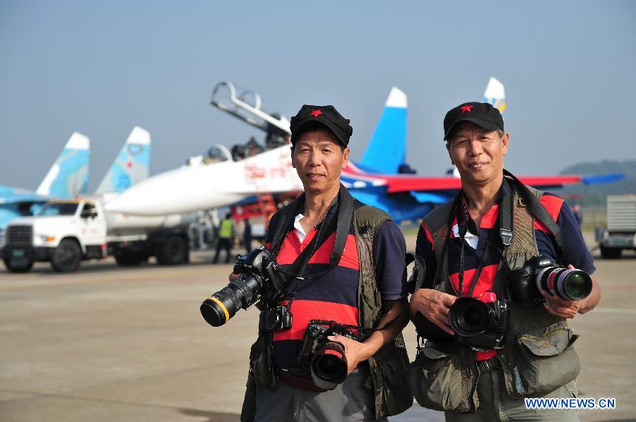 Lu Gang (R) and Lu Yan, twin photographers from Beijing, pose for photo during the 9th China International Aviation and Aerospace Exhibition in Zhuhai, south China's Guangdong Province, Nov. 12, 2012. The exhibition has attracted a large number of photograghers. Some of them are from media, some are from aviation industry corporations and others are big fans of aviation. (Xinhua/Yang Guang)