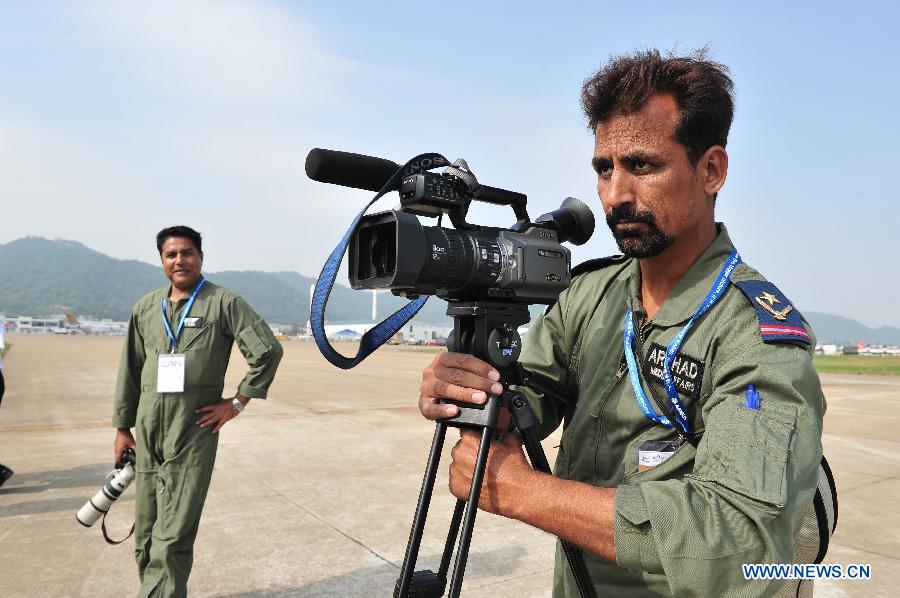 Pakistani armyman records a flight display during the 9th China International Aviation and Aerospace Exhibition in Zhuhai, south China's Guangdong Province, Nov. 11, 2012. The exhibition has attracted a large number of photograghers. Some of them are from media, some are from aviation industry corporations and others are big fans of aviation. (Xinhua/Yang Guang)