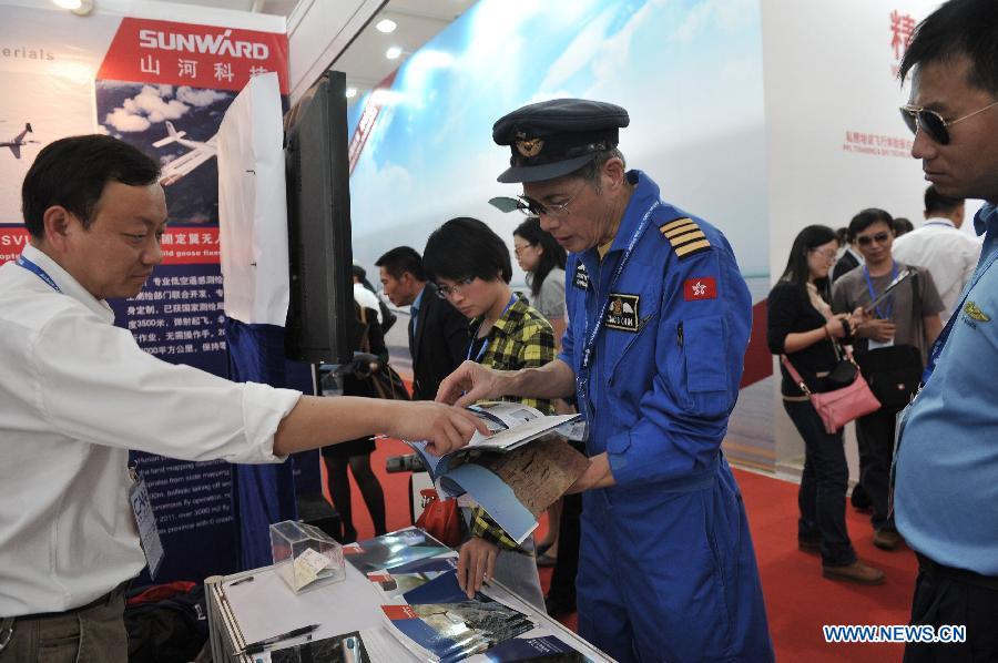 Visitors read the introduction booklets during the 9th China International Aviation and Aerospace Exhibition in Zhuhai, south China's Guangdong Province, Nov. 13, 2012. Some 650 manufactures at home and abroad attended the six-day airshow kicked off on Tuesday, which was expected to receive 400,000 visitors. (Xinhua/Yang Guang)