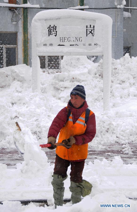 A working staff cleans snow piled aside tracks at the Hegang Railway Station in Hegang, northeast China's Heilongjiang Province, Nov. 13, 2012. Heavy snowstorms swept northeastern regions of Heilongjiang since last Sunday, forcing highways to close. Local authority of railway service initiated an emergency plan to maintain order of stranded passengers. (Xinhua/Wang Kai) 